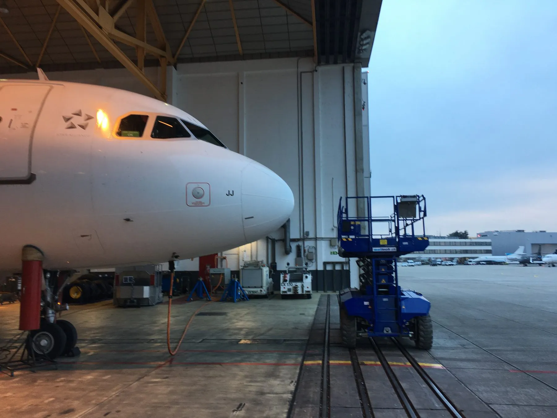 Verkehrsflugzeug im Hangar vor dem geöffneten Hangartor