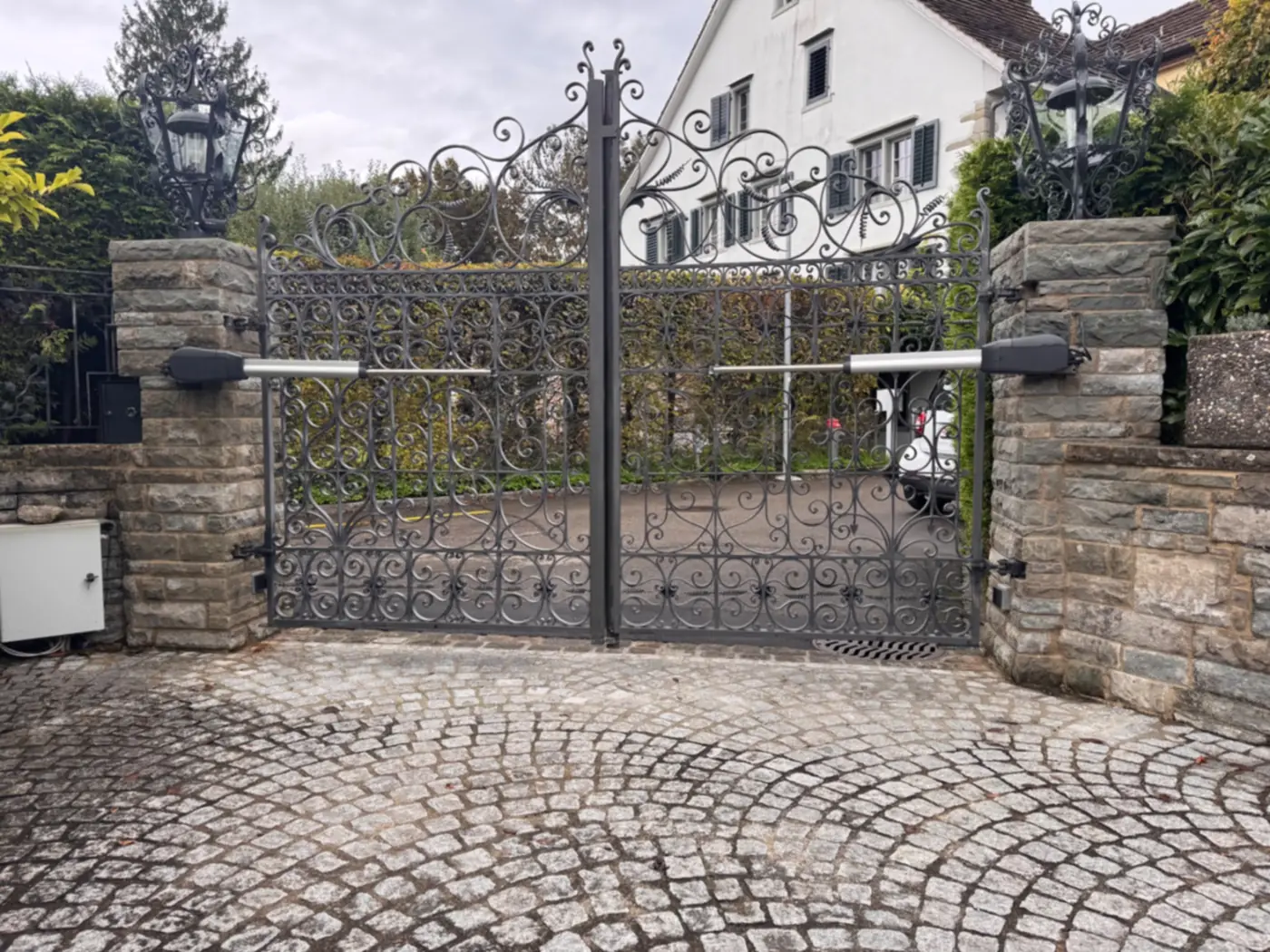 Neu montierte Antriebe an schmiedeeisernen Torflügeln in Erlenbach